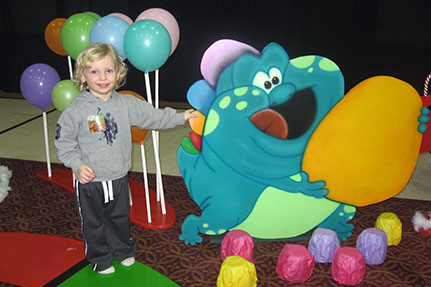 Child Standing Next to Candy Land Creature